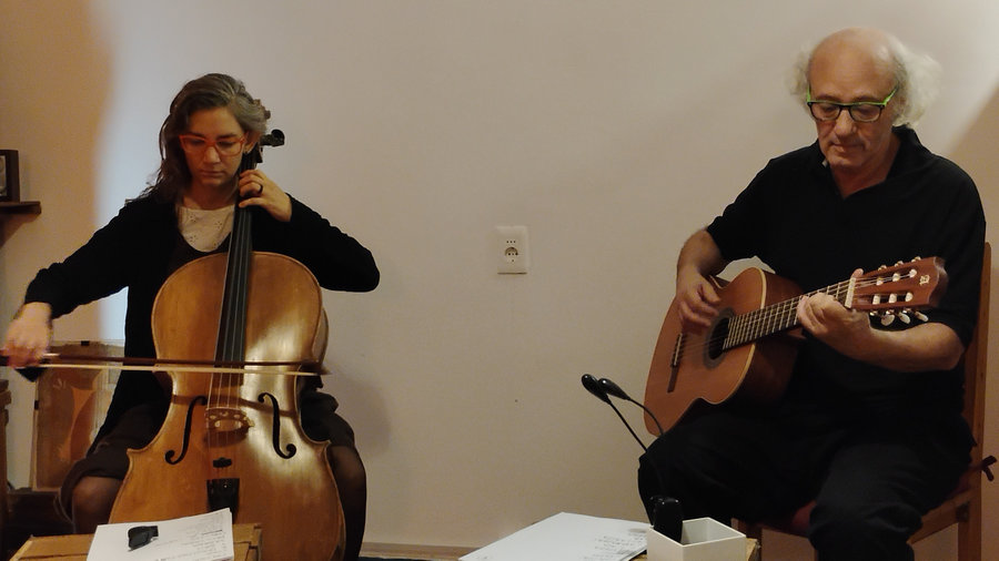 Celia con el chelo y Gullermo con guitarra, un rato antes de empezar el toque en el Mojo. Estan sentados y delante tienen un cajón rústico oficiando de atril, con papeles arriba. Celia con el chelo y Gullermo con guitarra, un rato antes de empezar el toque en el Mojo. Estan sentados y delante tienen un cajón rústico oficiando de atril, con papeles arriba.